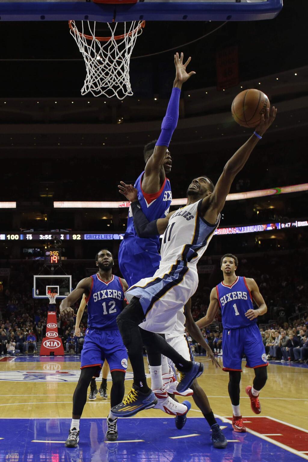 Memphis Grizzlies' Mike Conley (11) goes up for a shot against Philadelphia 76ers' Nerlens Noel during the second half of an NBA basketball game, Saturday, Dec. 13, 2014, in Philadelphia. Memphis won 120-115 in overtime. (AP Photo/Matt Slocum)