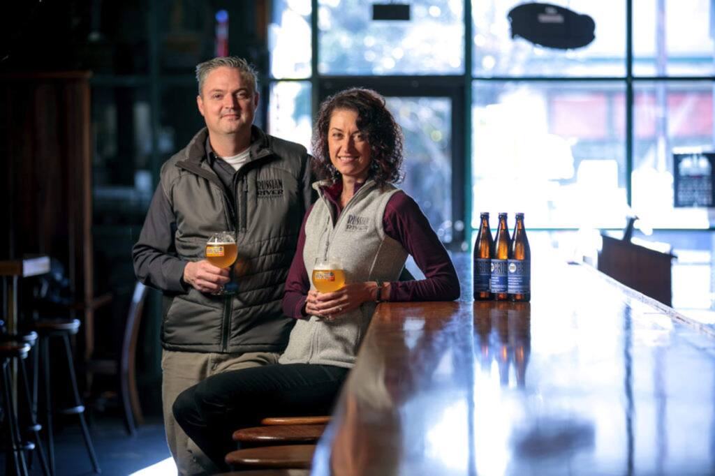 Natalie and Vinnie Cilurzo, of Russian River Brewing Company, at their brew pub in Santa Rosa in 2018 with Sonoma Pride beer they brewed to help Tubbs fire victims. (CHRIS HARDY)