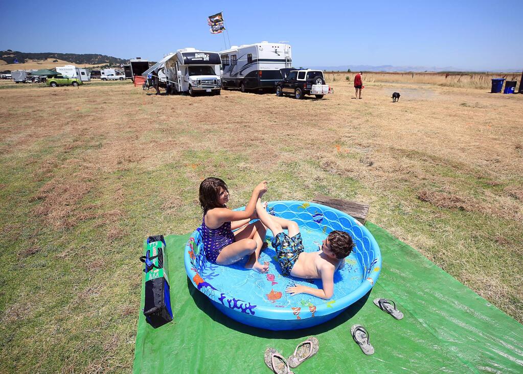 Rian, 9, and Cade Monaghan, 7 of Concord enjoy a brief dip in the pool as their grand mother and parents set up their camp at the 50 acre Lot at Sonoma Raceway, Thursday June 22, 2017. (Kent Porter / Press Democrat) 2017