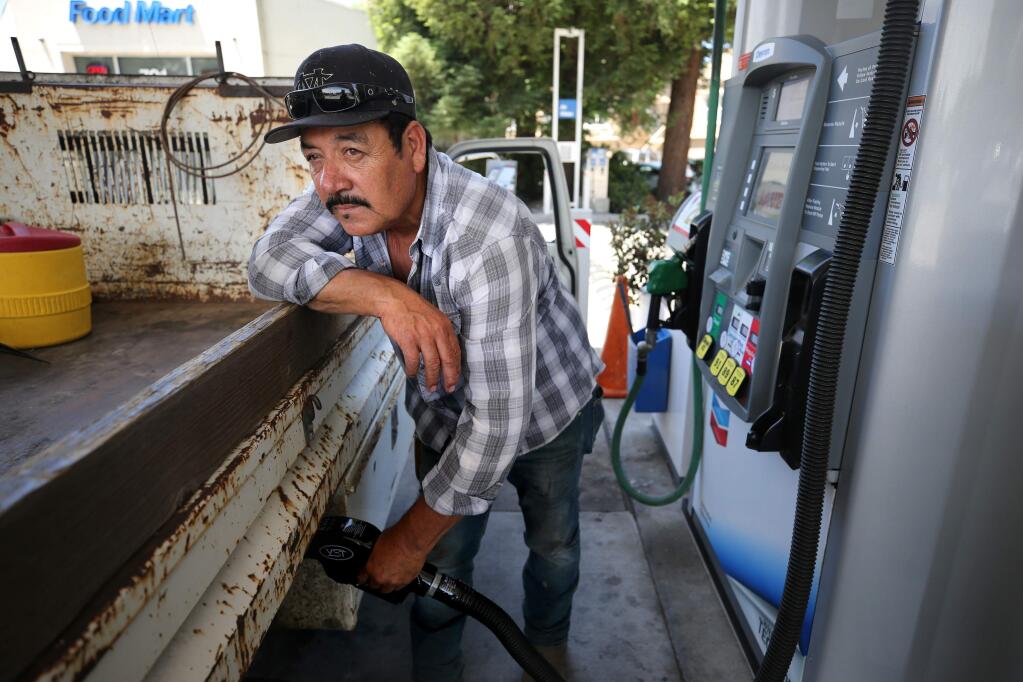 Refugio Arreguin fills up his tank at the Chevron station on the corner of College and Mendocino avenues in Santa Rosa on Monday, June 24, 2019. (BETH SCHLANKER/ The Press Democrat)