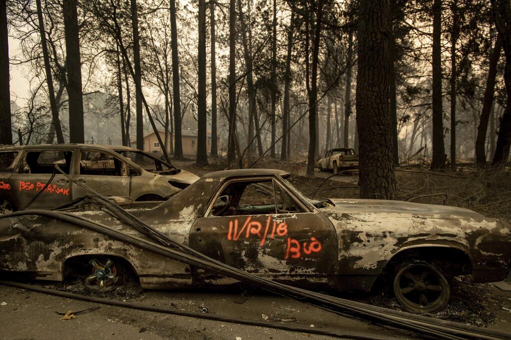 Following the Camp Fire, scorched cars line Pearson Road, Monday, Nov. 12, 2018, in Paradise, Calif. (AP Photo/Noah Berger)