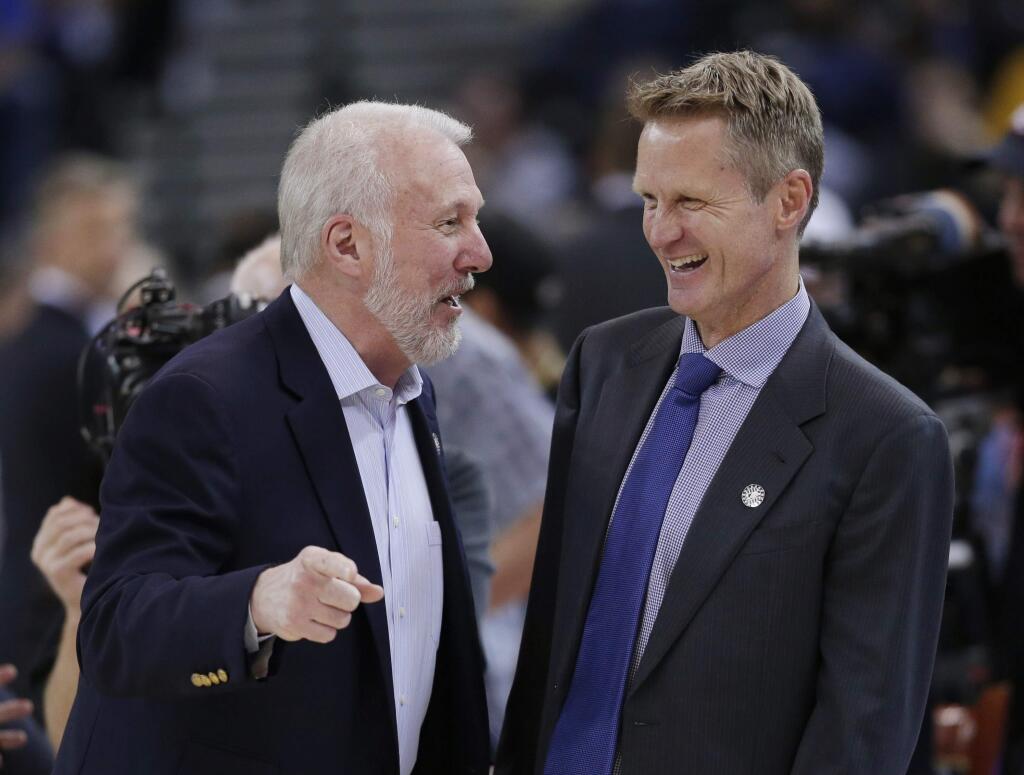 San Antonio Spurs coach Gregg Popovich, left, jokes with Golden State Warriors coach Steve Kerr before an NBA basketball game Tuesday, Nov. 11, 2014, in Oakland, Calif. (AP Photo/Marcio Jose Sanchez)