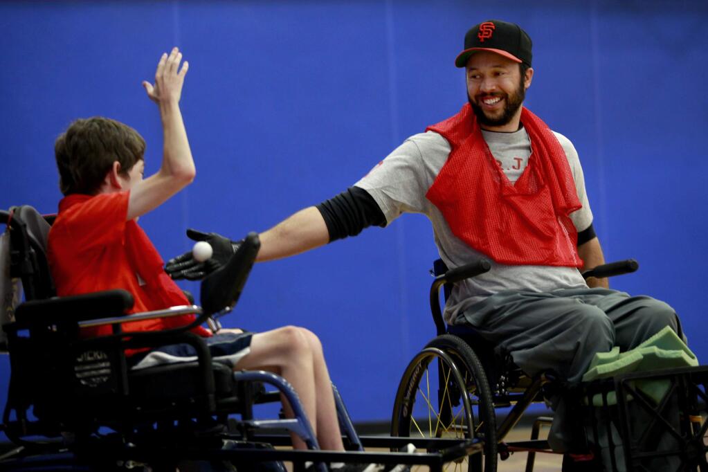 Anthony Hargrove, a member of the SRJC Rolling Bears wheelchair soccer team, right, high-fives Tyler Czapkay, 14, of the Sacramento Flames after scoring a goal during a inter-league scrimmage at Analy High School in Sebastopol, on Sunday, July 13, 2014. (BETH SCHLANKER/ The Press Democrat)
