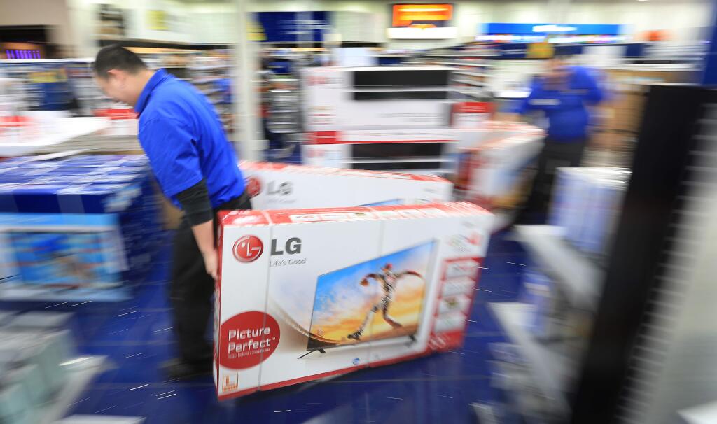 Best Buy employee Rob Saccuzzo moves televisions to a new display, Friday Dec. 26, 2014 at Best Buy in Sana Rosa. (Kent Porter / Press Democrat) 2014