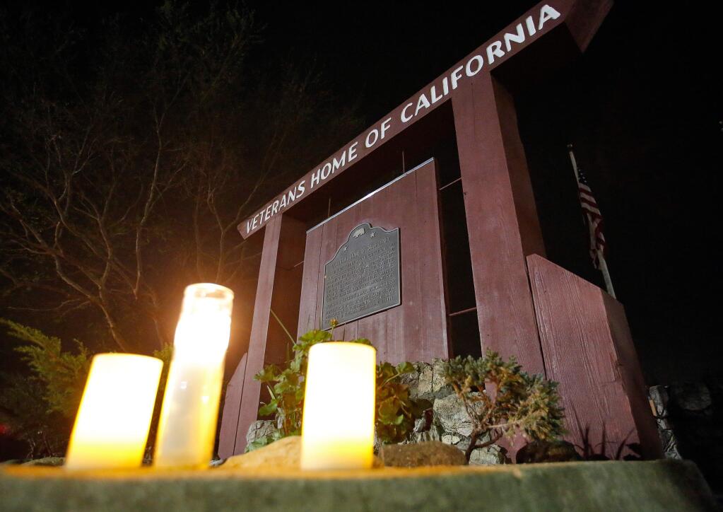 Candles forming a makeshift memorial sit in front of the entrance sign at the Veterans Home of California, where three people and the gunman who took them hostage were found deceased after a day-long standoff at the Pathway Home veterans support organization, in Yountville, California, on Friday, March 9, 2018. (Alvin Jornada / The Press Democrat)
