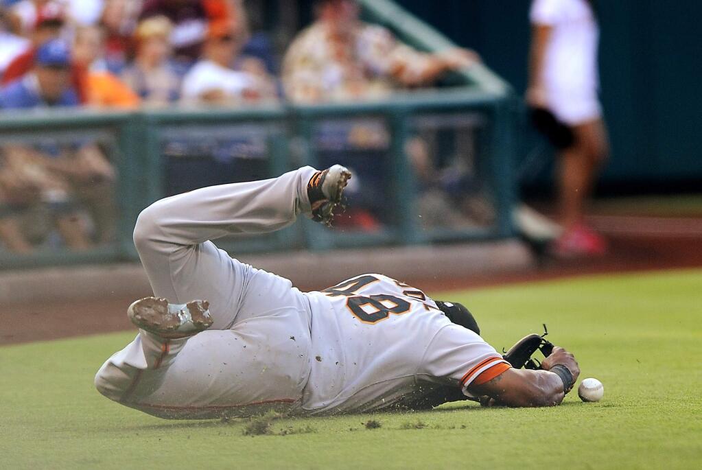 San Francisco Giants third baseman Pablo Sandoval dives for a pop up foul hit by Philadlephia Phillies' Ben Revere in the first inning of a baseball game on Tuesday, July 22, 2014, in Philadelphia. (AP Photo/Michael Perez)