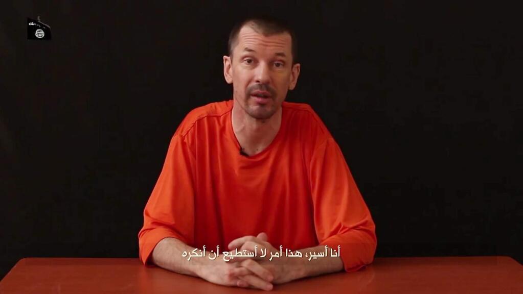 In this still image taken from an undated video published on the Internet by Al-Furqan, the media arm of the Islamic State group militants, captive British journalist John Cantlie speaks into the camera on the first of what he says will be a series of lecture-like 'programs' in which he says he will reveal 'the truth' about the Islamic State group. The Arabic subtitle reads 'I am a prisoner and that is something I will not deny.' (AP Photo)