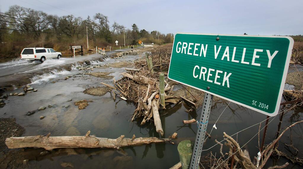 Sarcasm at Green Valley Road as someone moved the Green Valley Creek sign in to a flooded vineyard adjacent to the road. The creek has been flowing out of its banks for nearly a month and across the road as traffic has been reduced to one lane, Friday March 3, 2017 in Graton. (Kent Porter / The Press Democrat) 2017