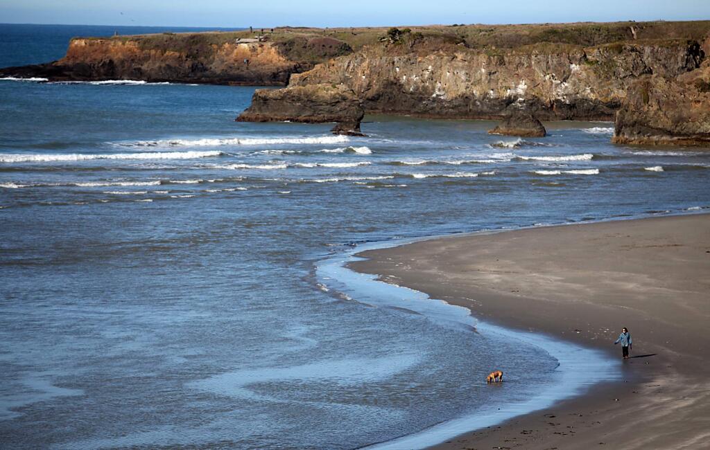 3/5/2012: A1:PC: Sue Morris of Mendocino walks with her dog Bogie at the mouth and estuary of Big River in Mendocino, Saturday March 3, 2012. (Kent Porter / Press Democrat) 2012