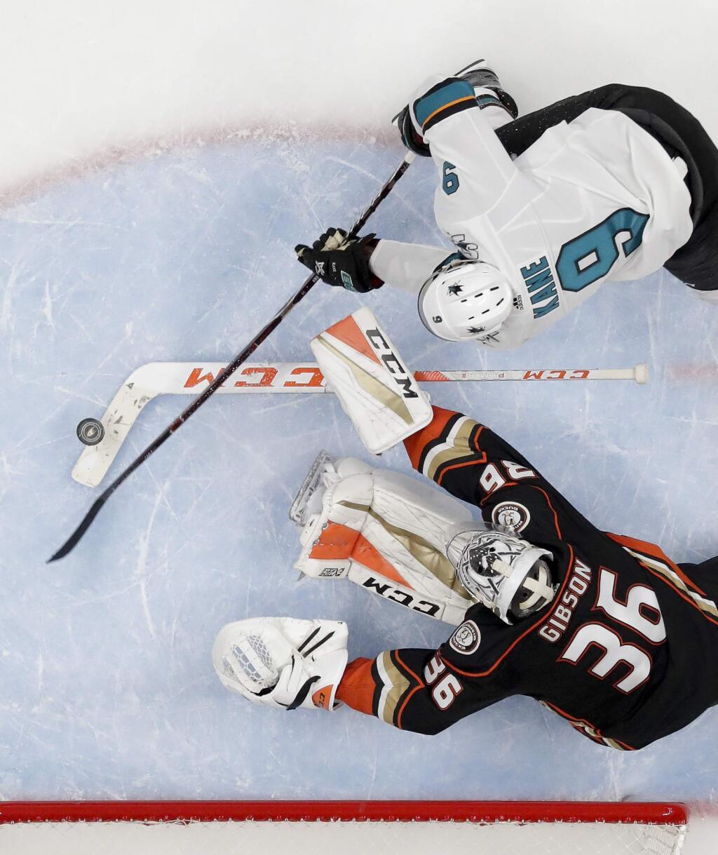 San Jose Sharks left wing Evander Kane, top, scores past Anaheim Ducks goaltender John Gibson during the second period of Game 1 of their first-round playoff series in Anaheim, Thursday, April 12, 2018. (AP Photo/Reed Saxon)