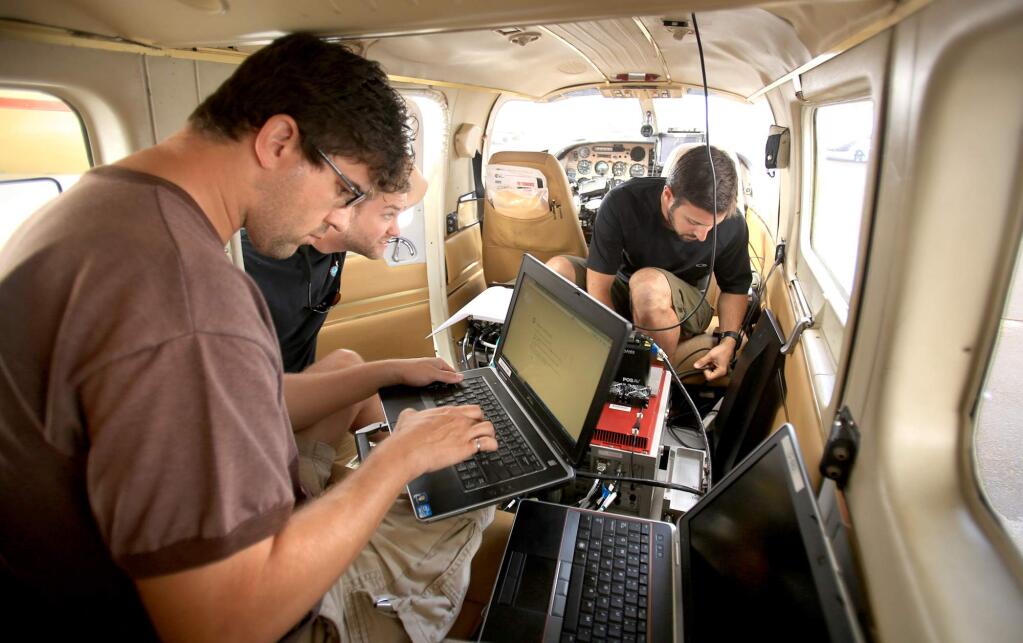 A team of specialists, Craig Glennie, Darren Hauser and Adam LeWinter coordinate equipment to take aerial information along the Napa earthquake fault as they work with the USGS before takeoff at the Napa Airport, Wednesday Aug. 19, 2015 in Napa. (Kent Porter / Press Democrat) 2015