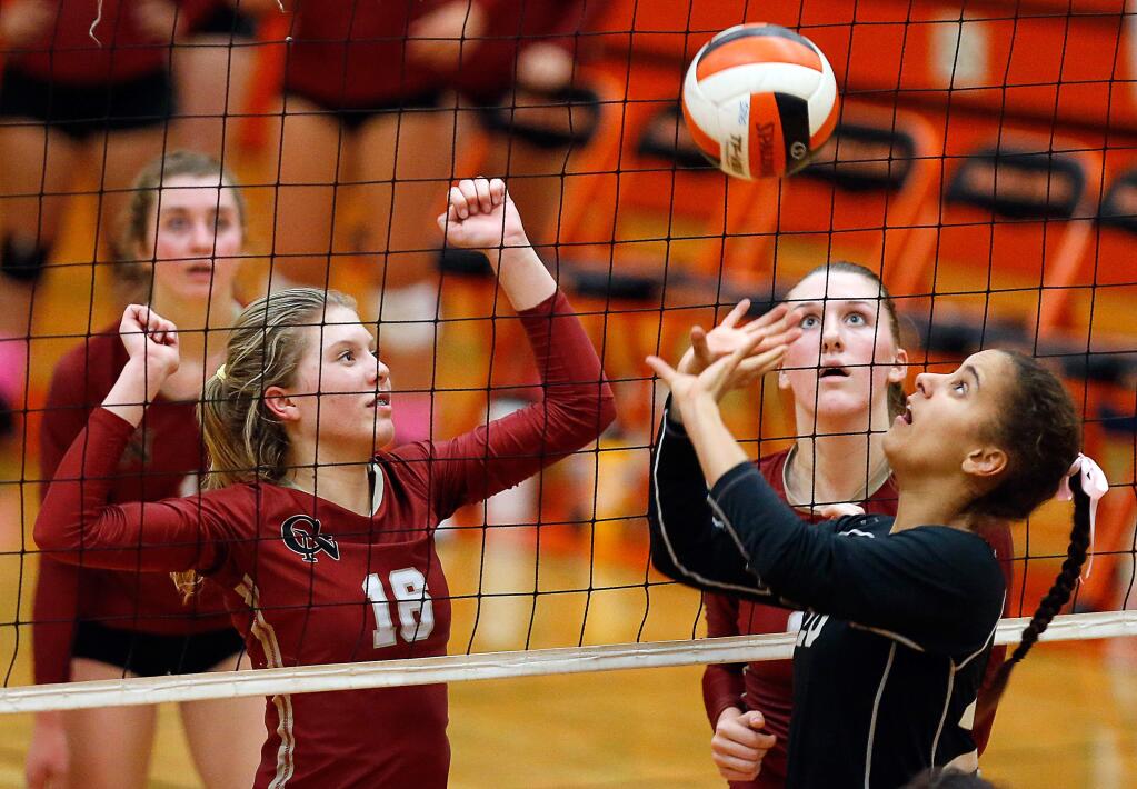 Cardinal Newman's Kimi Waller (16), left, and Julia Donlon (21) anticipate a set by Santa Rosa's Isa Ponce (20 during a varsity volleyball game between Cardinal Newman and Santa Rosa high schools, in Santa Rosa, California, on Tuesday, October 9, 2018. (Alvin Jornada / The Press Democrat)