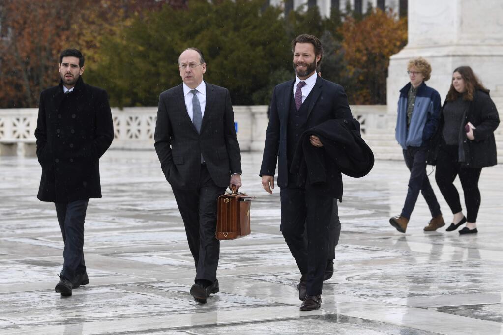 Attorney Paul Clement, second from left, walks to make a statement outside of the Supreme Court in Washington, Monday, Dec. 2, 2019, following arguments in the first gun rights case before the Supreme Court in nine years. The case was filed by three New York City gun owners who are challenging a ban on carrying a licensed handgun outside city limits to a gun range, shooting competition or second home outside city limits. (AP Photo/Susan Walsh)