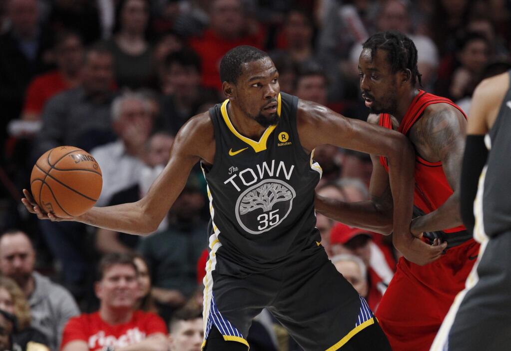 Golden State Warriors forward Kevin Durant, left, looks to pass against Portland Trail Blazers forward Al-Farouq Aminu during the second half Wednesday, Feb. 14, 2018. The Trail Blazers won 123-117. (AP Photo/Steve Dipaola)