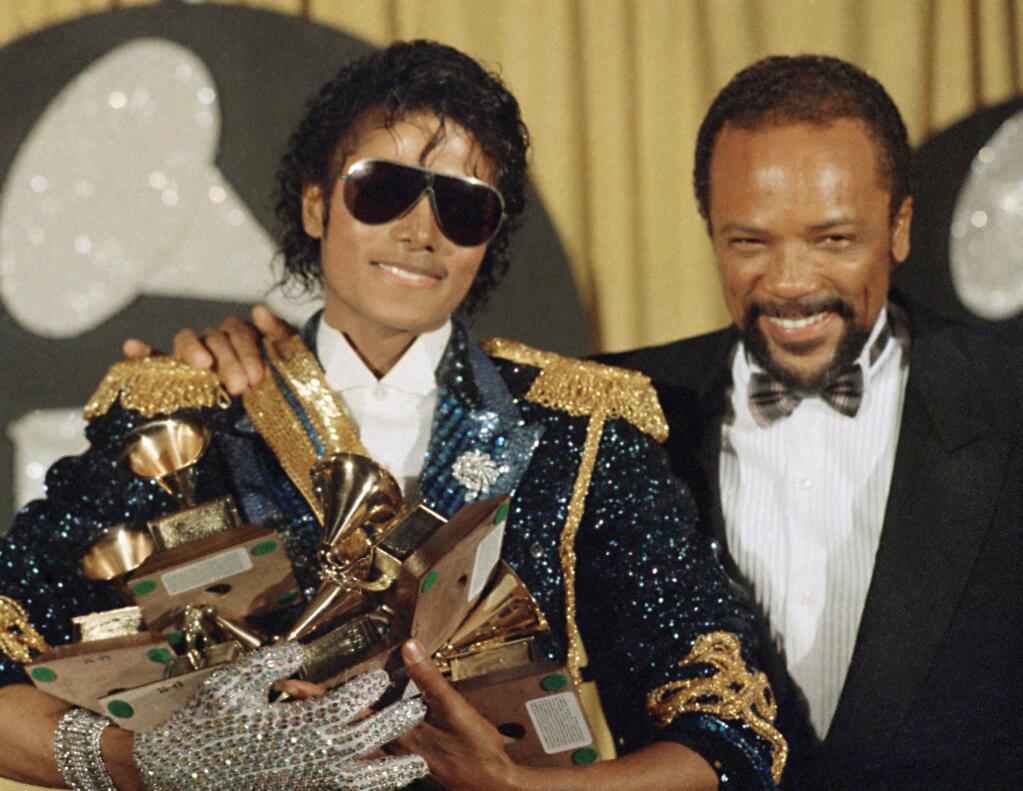 FILE - In this Feb. 28, 1984 file photo, Michael Jackson, left, holds eight awards as he poses with Quincy Jones at the Grammy Awards in Los Angeles. On Wednesday, July 26, 2017, a jury found that Jackson's estate owes Jones $9.4 million in royalties and production fees from “Billie Jean,” “Thriller” and more of the superstar's biggest hits. (AP Photo/Doug Pizac, File)