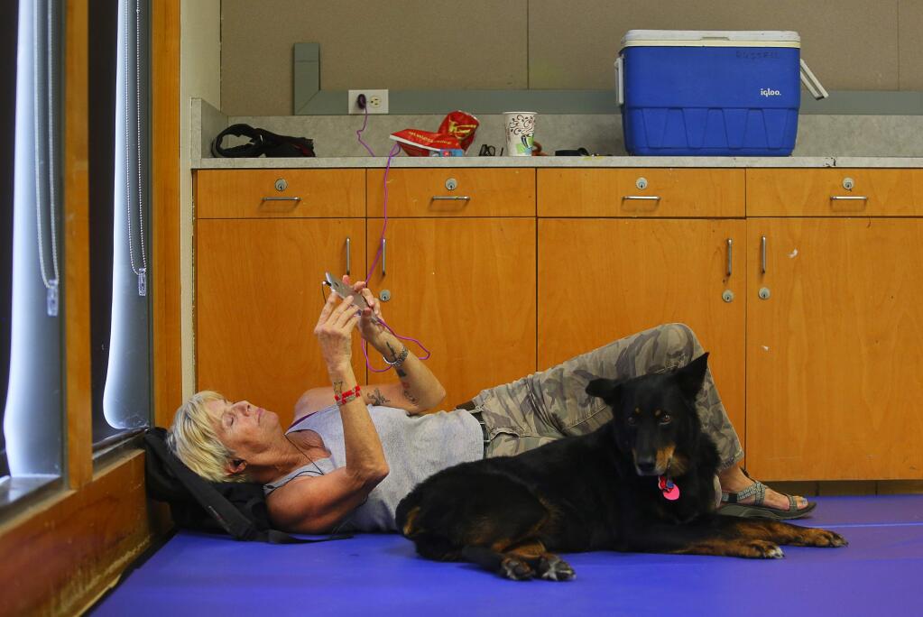 Giulia Latini and her dog, Bee, take advantage of the cooling center at Finley Community Center to beat the high temperatures in Santa Rosa on Friday, September 1, 2017. (Christopher Chung/ The Press Democrat)