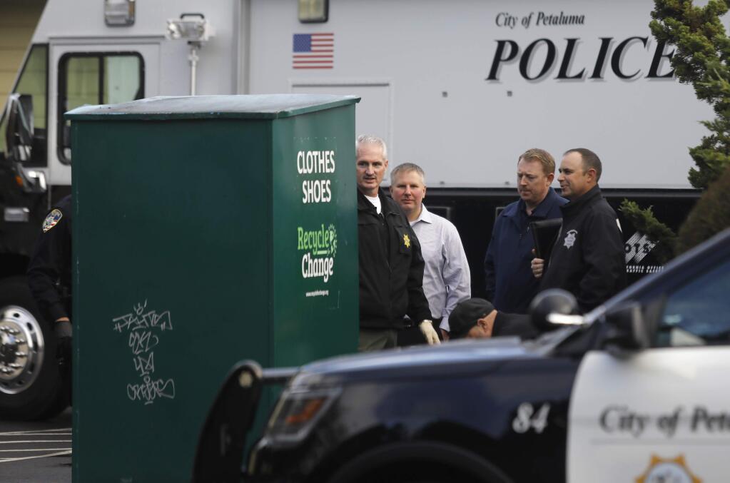 Petaluma police investigate the scene where a woman was found dead in a clothing donation box outside the Steel Bear Deli and Country Store in Petaluma on Wednesday, November 28, 2018. (BETH SCHLANKER/ The Press Democrat)