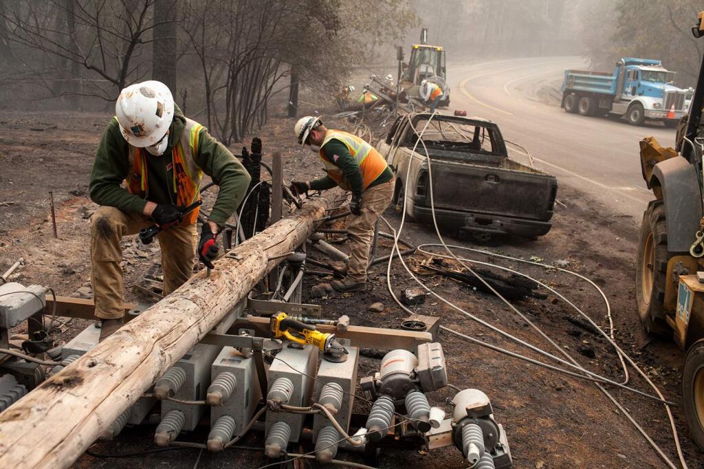 PG&E workers dissemble broken power lines after the Camp fire ripped through Paradise on Nov. 15. (JOEL ANGEL JUAREZ / Zuma Press)