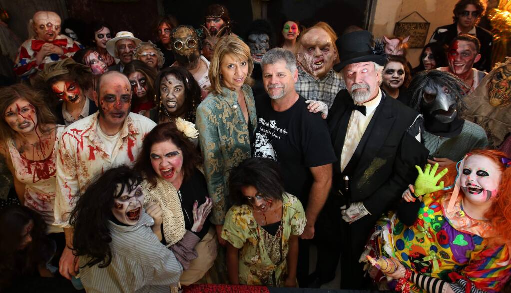 Judy Groverman Walker, center left, Drew Dominguez, center, right, owners of Blind Scream haunted house in Sonoma mountain Village in Rohnert Park, are surrounded by the actors, Sunday, October 19, 2014. (Crista Jeremiason / The Press Democrat)