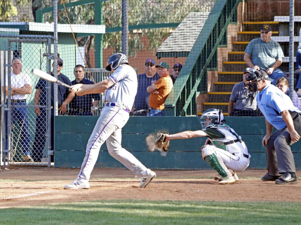 A dust cloud flies from catcher Logan Mak's glove as a Petaluma batter swings and misses during a recent game at Arnold Field. (Christian Kallen/Index-Tribune)
