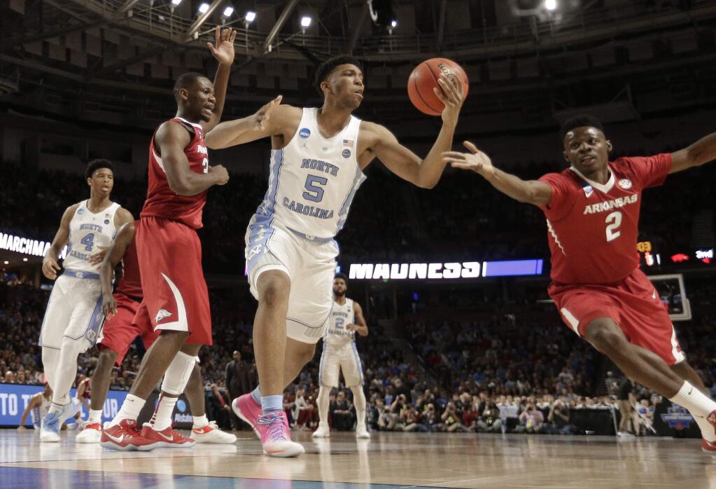 North Carolina's Tony Bradley (5) reaches for the ball as Arkansas' Adrio Bailey (2) closes in during the second half in a second-round game of the NCAA men's college basketball tournament in Greenville, S.C., Sunday, March 19, 2017. (AP Photo/Rainier Ehrhardt)