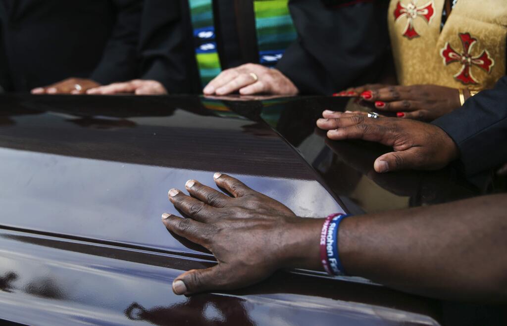 Members of the clergy and community place their hands upon two empty coffins symbolizing the double-murder of black victims' bodies and their names during a protest prior to the start of the NFL football game between the Dallas Cowboys and New York Giants, Sunday, Sept. 16, 2018, at AT&T Stadium in Arlington, Texas. The demonstration comes after Botham Jean was shot in his home by Dallas Police Officer Amber Guyger. (Ryan Michalesko/The Dallas Morning News)