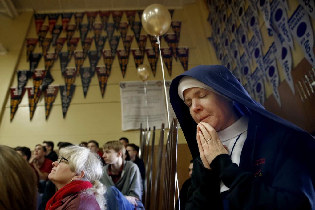 Sister Teresa Christe joins with students, parents, faculty and guests in prayer during an assembly to mark the first day back at Cardinal Newman High School in Santa Rosa, on Monday, January 22, 2018. (BETH SCHLANKER/ The Press Democrat)