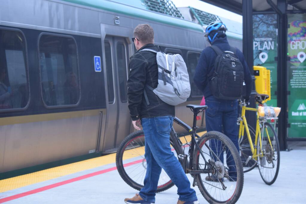 Bob Hostutler, left, and another cyclist wheel their bikes toward the 8:31 a.m. train at Santa Rosa's downtown station on Jan. 23, 2018. (James Dunn / North Bay Business Journal)