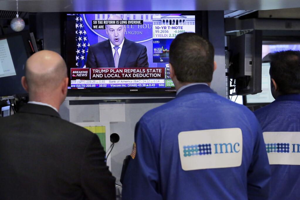 Specialists on the floor of the New York Stock Exchange watch Gary Cohn, director of the White House National Economic Council, Wednesday, April 26, 2017. President Donald Trump proposed dramatic cuts in the taxes paid by corporations big and small Wednesday in an overhaul his administration says will spur economic growth and bring jobs and prosperity to America's middle class. (AP Photo/Richard Drew)