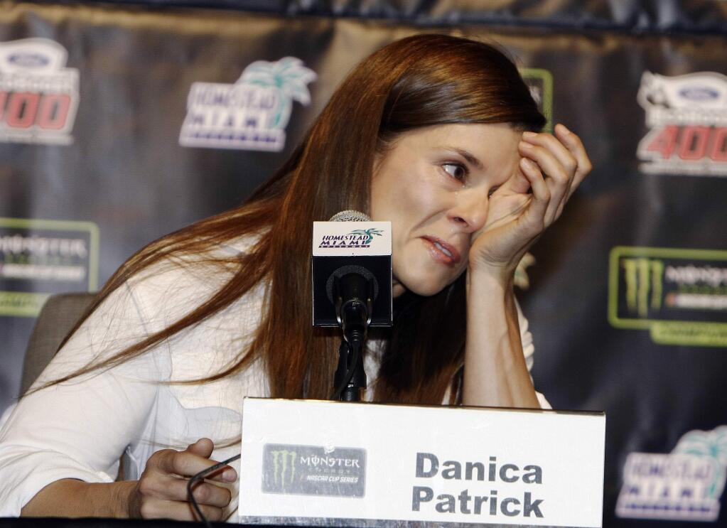 Danica Patrick wipes away tears as he speaks with the media during a news conference before Sunday's NASCAR Cup Series race at Homestead-Miami Speedway in Homestead, Fla., Friday, Nov. 17, 2017. Patrick will end her full-time racing career after running in next year's Daytona 500 and Indianapolis 500. (AP Photo/Darryl Graham)