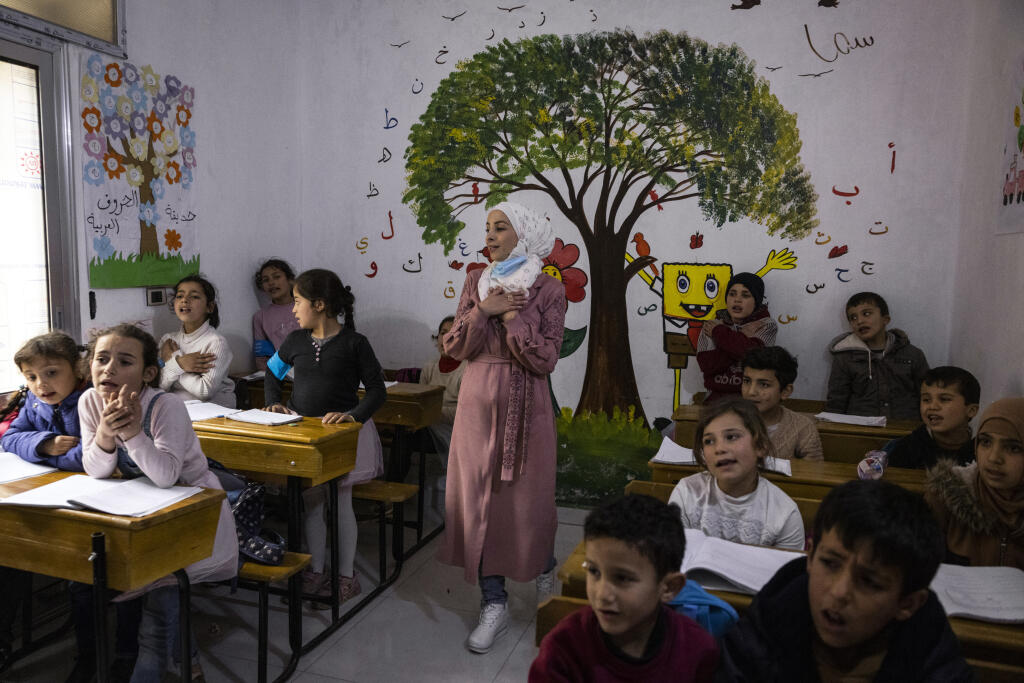 Rafif Neen, a teacher, leads a class at a school for children who are orphans or have lost a parent in Idlib, Syria, on March 24, 2021. Millions of people displaced during Syria’s 10-year war are impoverished, insecure and crowded into an area of the country’s northwest controlled by a rebel group once linked to al-Qaida. (Ivor Prickett/The New York Times)