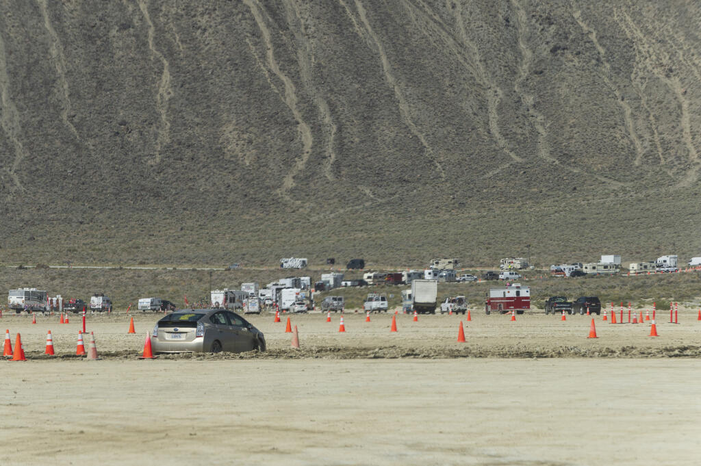 Vehicles line up to leave the Burning Man festival in Black Rock Desert, Nev., Tuesday, Sept. 5, 2023. The traffic jam leaving the festival eased up considerably Tuesday as the exodus from the mud-caked Nevada desert entered a second day following massive rain that left tens of thousands of partygoers stranded there for days. (Monique Sady via AP)