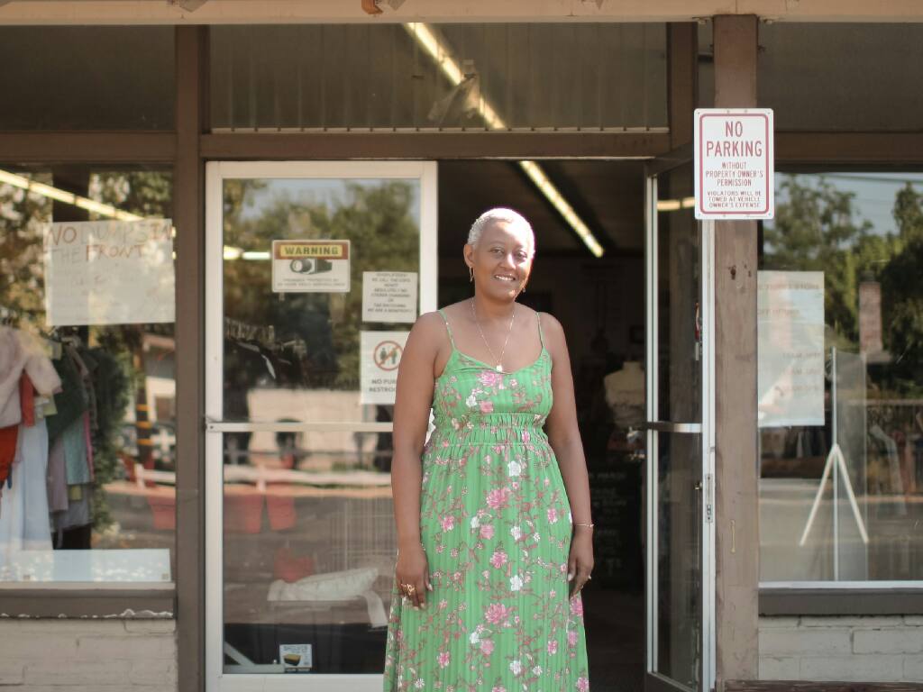 Anna Bimenyimana, owner of Bon Marche Thrift Store, in front of the store. (Aimee Chavez/Aimee’s Gallery)