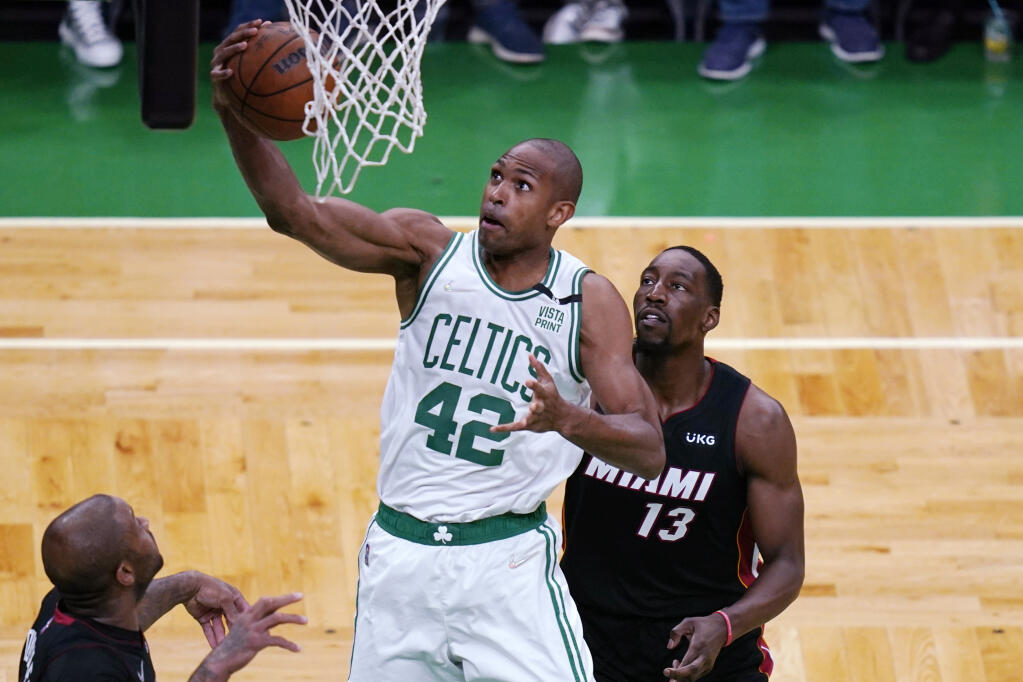 Boston Celtics center Al Horford (42) grabs a rebound against Miami Heat center Bam Adebayo (13) during the first half of Game 4 of the NBA basketball playoffs Eastern Conference finals, Monday, May 23, 2022, in Boston. (AP Photo/Charles Krupa)