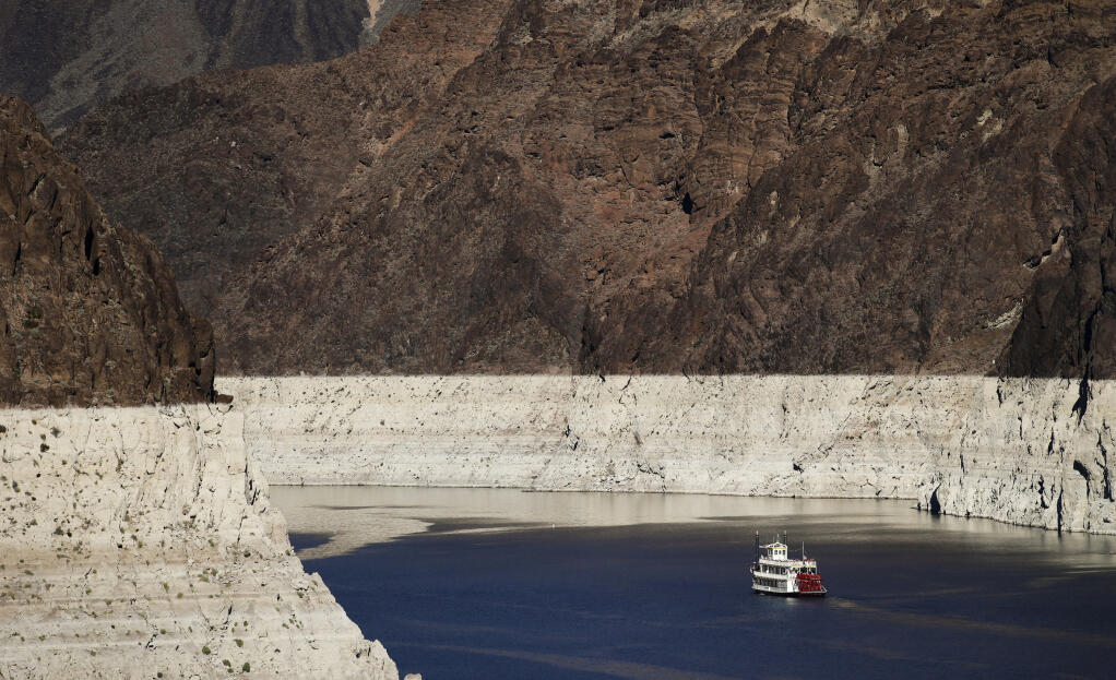FILE - In this Oct. 14, 2015, file photo, a riverboat glides through Lake Mead on the Colorado River at Hoover Dam near Boulder City, Nev. The key reservoir on the Colorado River is expected to match its record low level on Thursday, June 10, 2021. The dropping surface elevation of Lake Mead along the Arizona-Nevada border is the another sign of the drought's grip on the region. (AP Photo/Jae C. Hong, File)