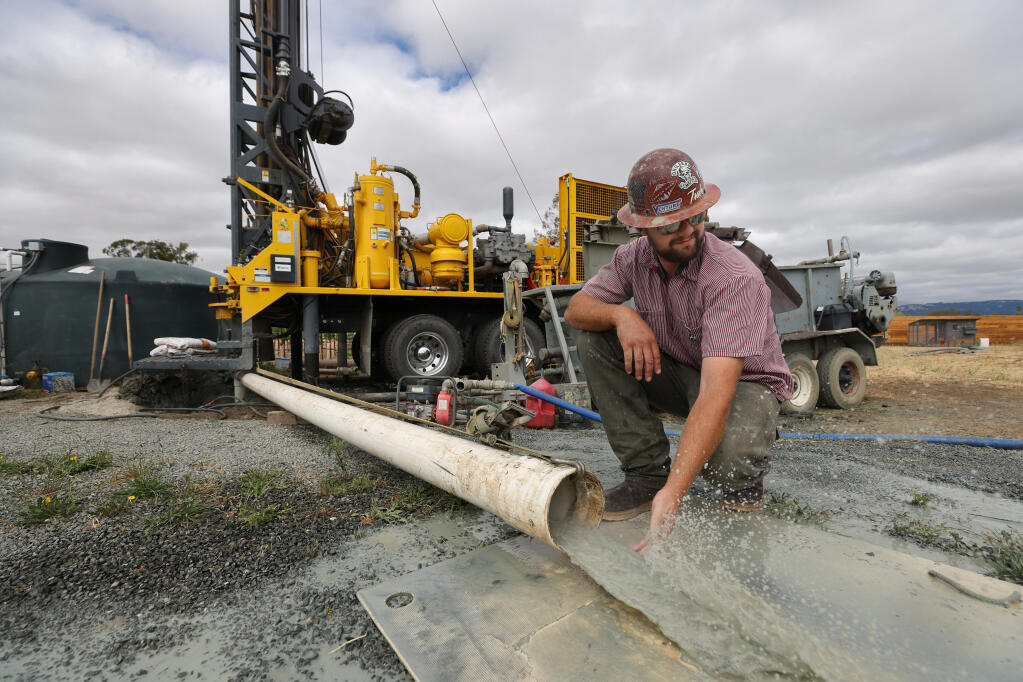 Weeks Drilling & Pump Co. operator foreman Nick Riojas checks water flowing from a new well on a vineyard property near Sonoma on Tuesday, June 22, 2021.  (Christopher Chung / The Press Democrat)
