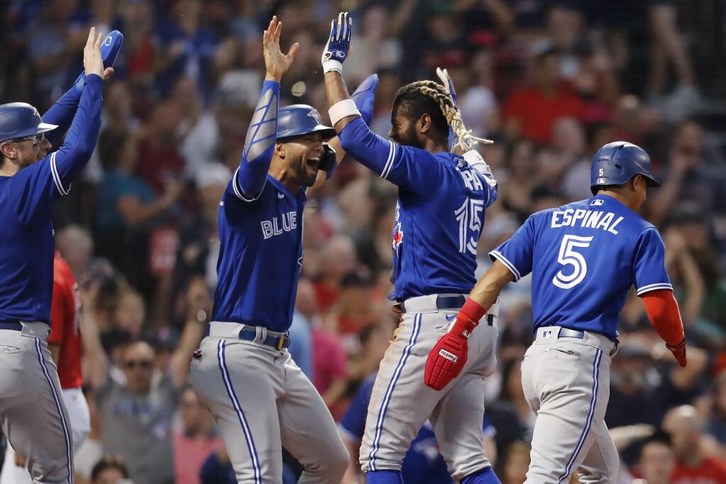The Toronto Blue Jays’ Raimel Tapia, second from right, celebrates his inside-the-park grand slam that scored Lourdes Gurriel Jr., center left, Danny Jansen, left, and Santiago Espinal during the third inning against the Red Sox on Friday, July 22, 2022, in Boston. (Michael Dwyer / ASSOCIATED PRESS)