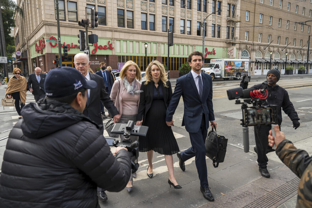 Theranos founder and CEO Elizabeth Holmes, center, walks into federal court with her partner Billy Evans (right) and her parents in San Jose, Calif., Friday, Nov. 18, 2022. (AP Photo/Nic Coury)