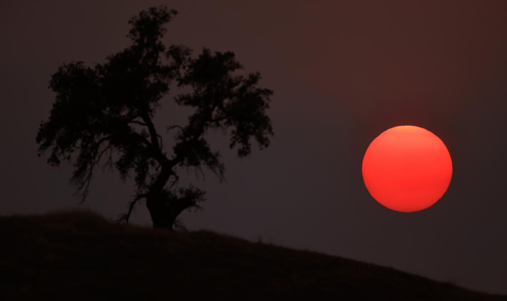 Smoky skies over created a filtered sunset earlier this month in this photograph taken from the Geysers area of Sonoma County. Wildfire smoke triggered an air quality advisory for the Bay Area on Monday, Aug. 23, 2021. (Kent Porter / The Press Democrat)