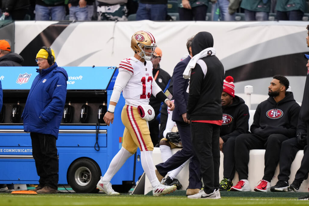 San Francisco 49ers quarterback Brock Purdy walks with a trainer on the sideline during the first half of the NFC Championship NFL football game between the Philadelphia Eagles and the San Francisco 49ers on Sunday, Jan. 29, 2023, in Philadelphia. (AP Photo/Matt Slocum)