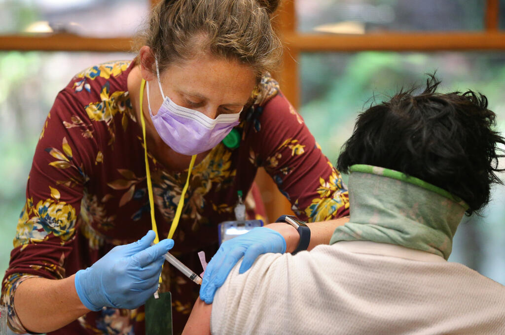Santa Rosa Community Health registered nurse Natalie Hogan administers the Johnson & Johnson COVID-19 vaccine to a patient during a vaccination clinic for individuals in congregate homeless shelters, at Alliance Redwoods near Occidental on Thursday, March 25, 2021.  (Christopher Chung/ The Press Democrat)