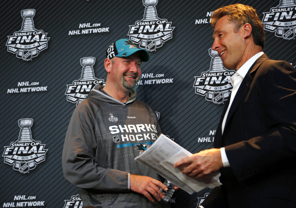 San Jose Sharks head coach Peter DeBoer, left, and general manager Doug Wilson pass each other on the way out of a press conference during Stanley Cup Finals Media Day at the Consol Energy Center in Pittsburgh, Sunday May 29, 2016. The Sharks face-off against the Pittsburgh Penguins in  Game 1 of the Stanley Cup Finals  Monday, May 30, in Pittsburgh. (AP Photo/Gene J. Puskar)