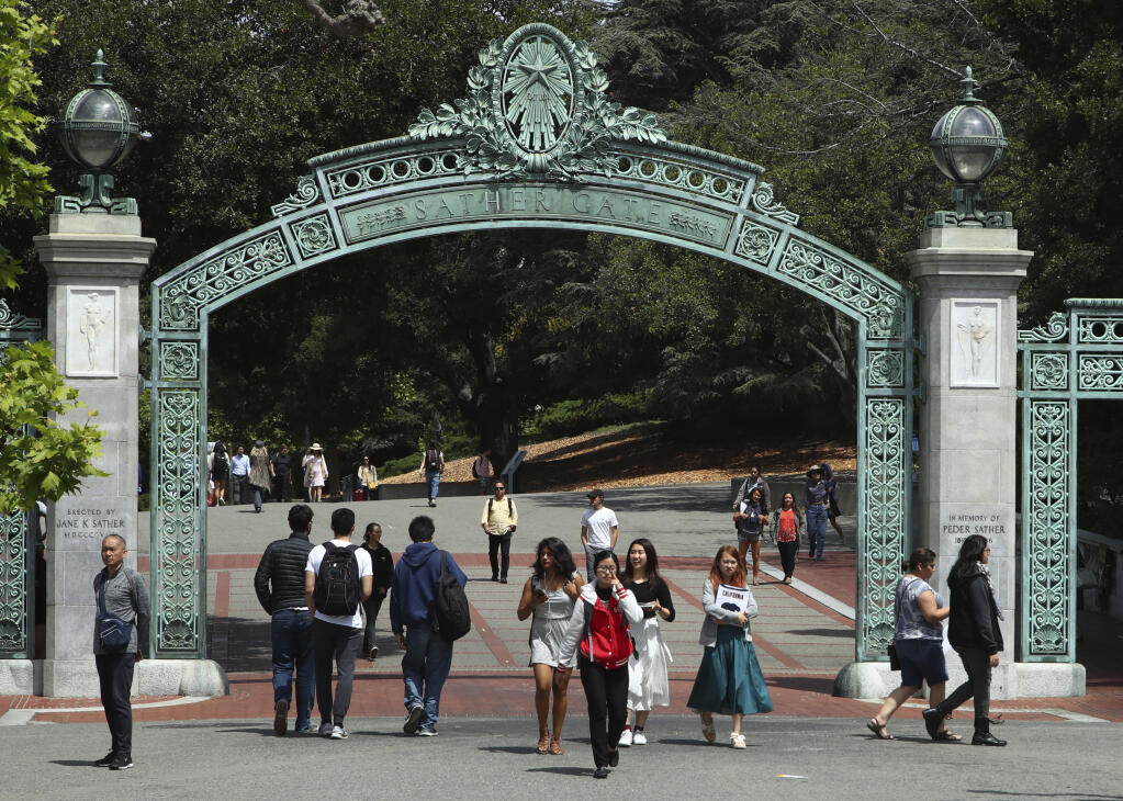 FILE - In this May 10, 2018, file photo, students walk past Sather Gate on the University of California at Berkeley campus in Berkeley, Calif. (AP Photo/Ben Margot, File)