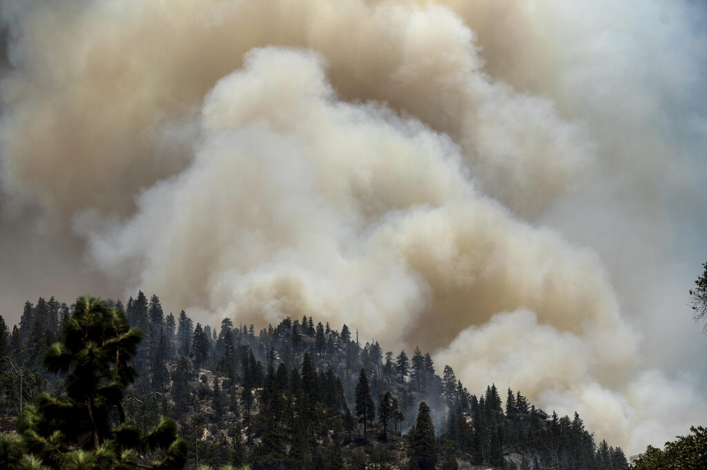Smoke rises from the Dixie fire burning along Highway 70 in Plumas National Forest, Calif., on Friday, July 16, 2021. (AP Photo/Noah Berger)