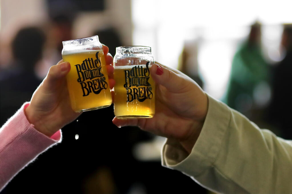 Two people toast glasses of beer during the 26th Annual Battle of the Brews, at the Sonoma County Fairgrounds, Saturday, April 1, 2023, in Santa Rosa. Santa Rosa is the drunkest city in the state, according to a report out this month by 24/7 Tempo. (Darryl Bush / For The Press Democrat file)