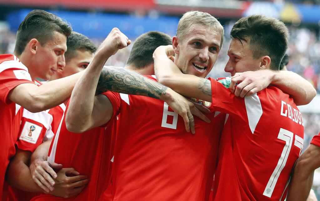 Russia's Yuri Gazinsky celebrates with teammates after scoring his side's first goal during the group A match between Russia and Saudi Arabia which opens the 2018 soccer World Cup at the Luzhniki stadium in Moscow, Russia, Thursday, June 14, 2018. (AP Photo/Matthias Schrader)