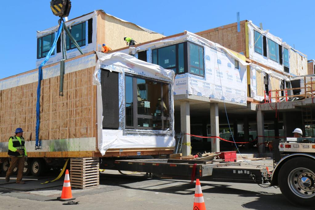 As seen from Davis Street, two-room modules for the AC Hotel project are hoisted into position on Tuesday, June 18, 2019. (Jeff Quackenbush / North Bay Business Journal)