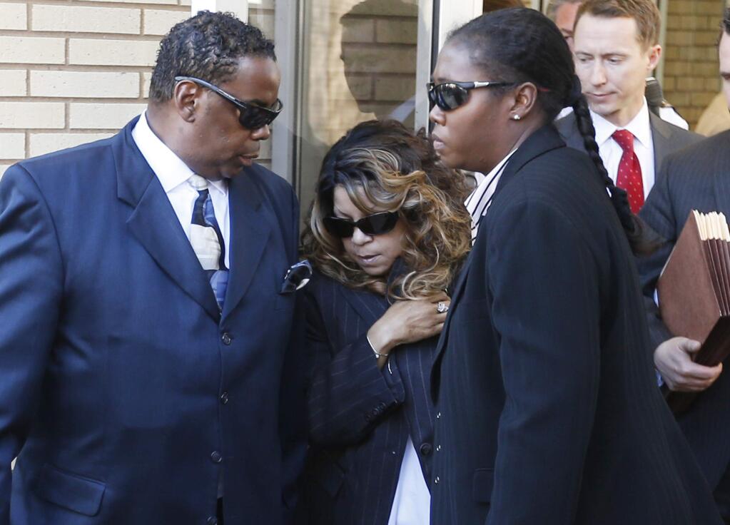 Tyka Nelson, center, the sister of Prince, is escorted by unidentified people as she leaves the Carver County Courthouse Monday, May 2, 2016, in Chaska, Minn. where a judge has confirmed the appointment of a special administrator to oversee the settlement of Prince's estate. The pop rock singer died on April 21 at the age of 57. (AP Photo/Jim Mone)