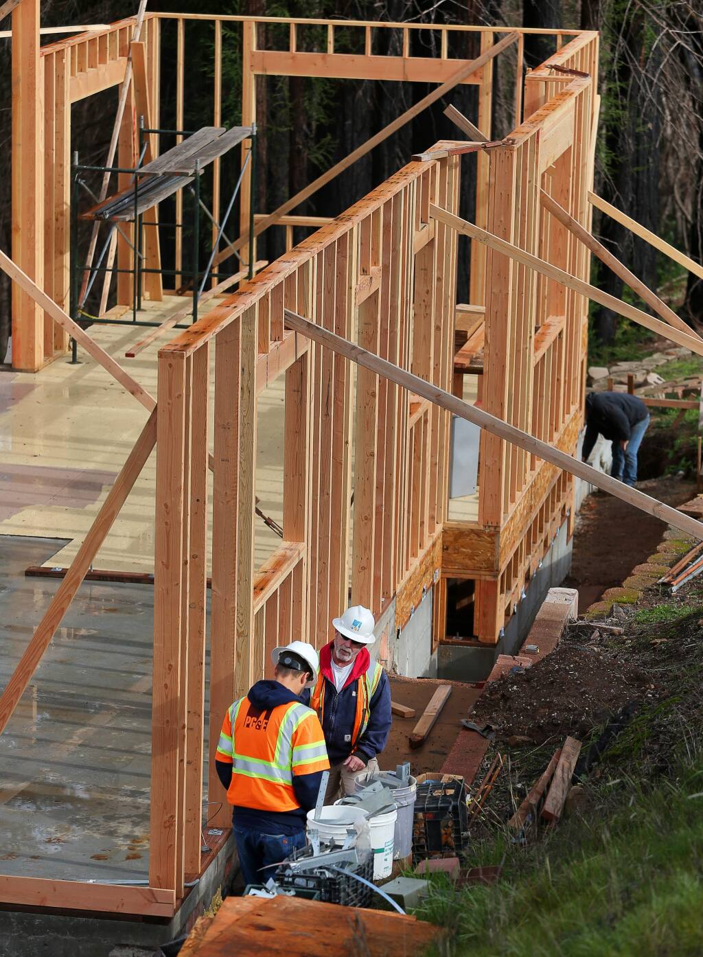 PG&E workers look at a house being rebuilt on Skyfarm Drive in the Fountaingrove area of Santa Rosa, as they work on restoring residential power on Monday, Jan. 14, 2019. (CHRISTOPHER CHUNG/ PD)