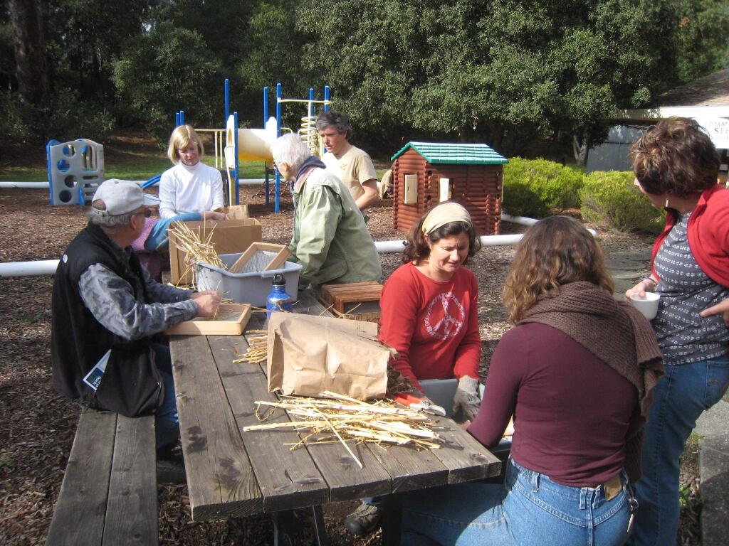 Community Seed Exchange members clean seeds at a recent gathering.